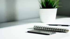 pen, notebook, phone on table
