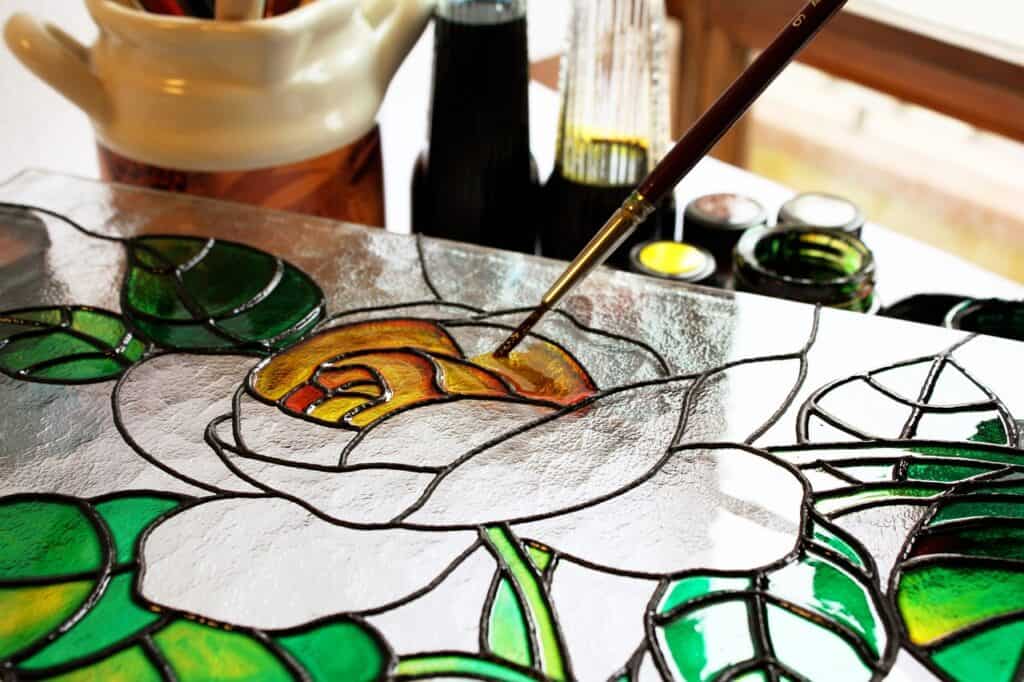 Someone painting a stained glass rose