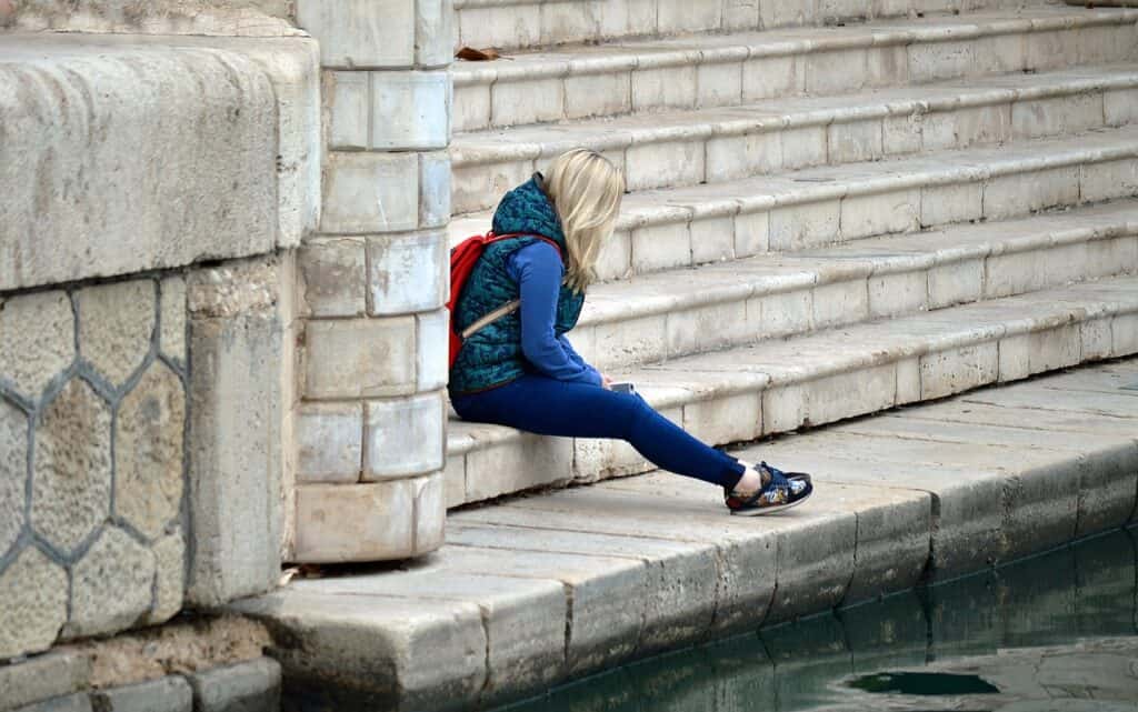 girl sitting alone against a wall