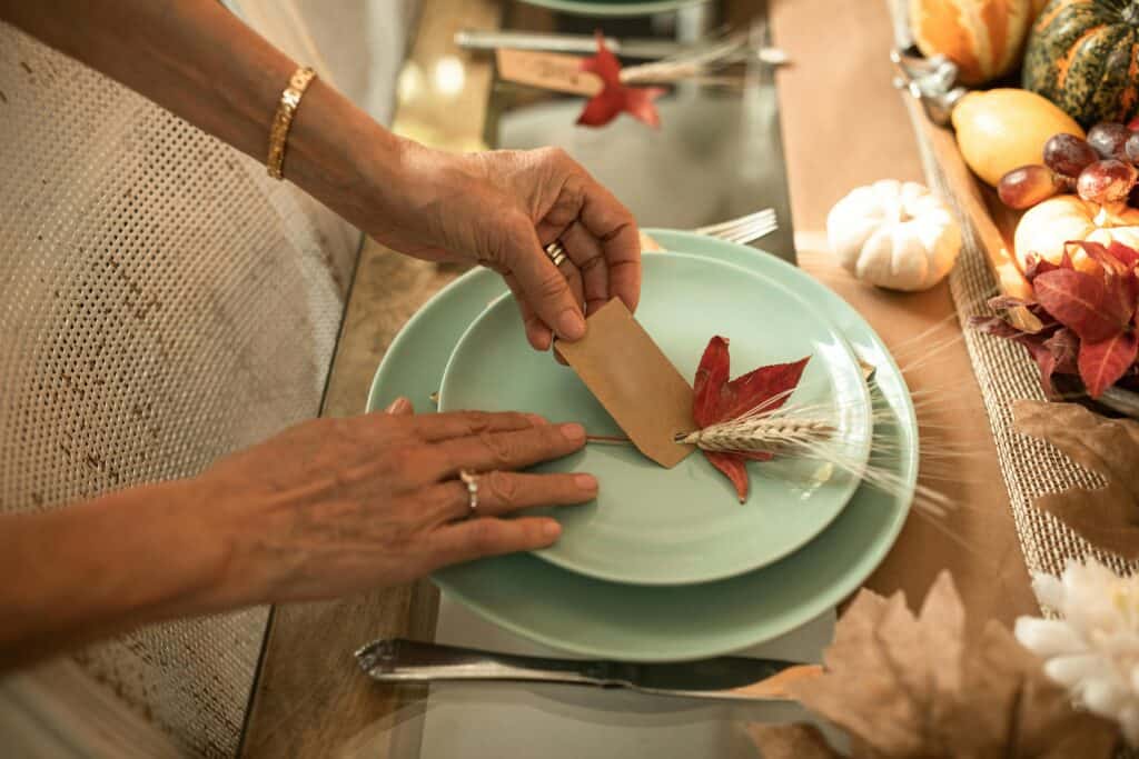 woman's hands setting Thanksgiving table