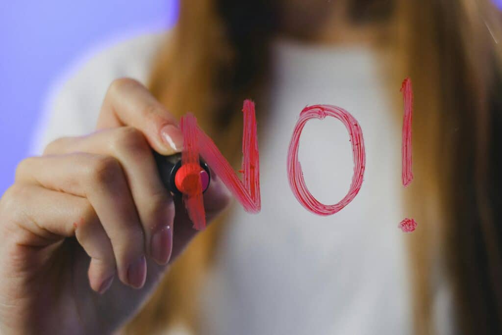 girl writing NO on glass with lipstick