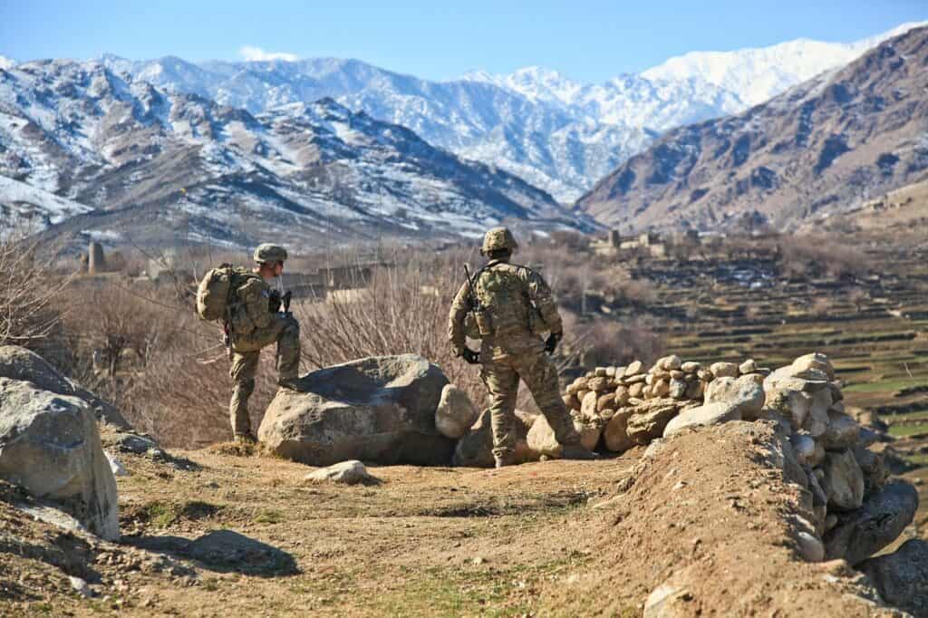 Army soldiers looking out over mountains