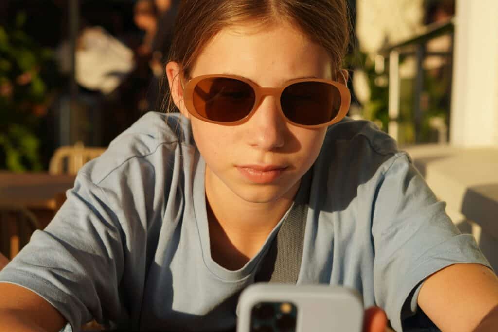 girl wearing sunglasses on cell phone