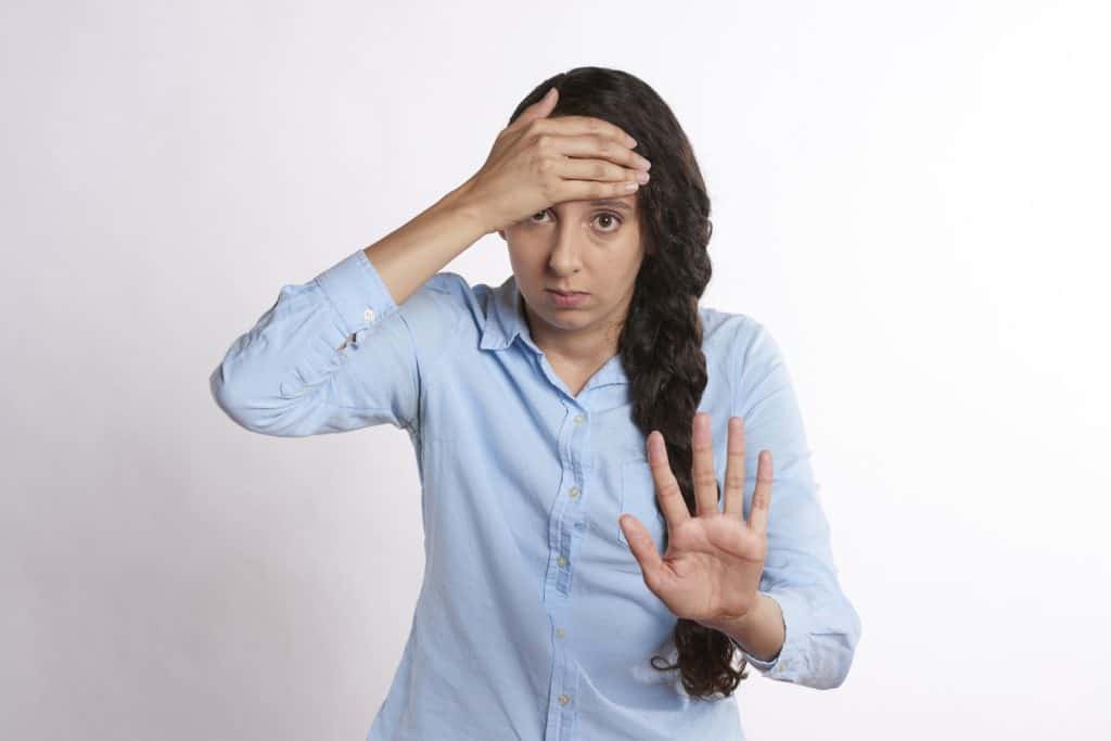 annoyed woman with hand held out to say stop
