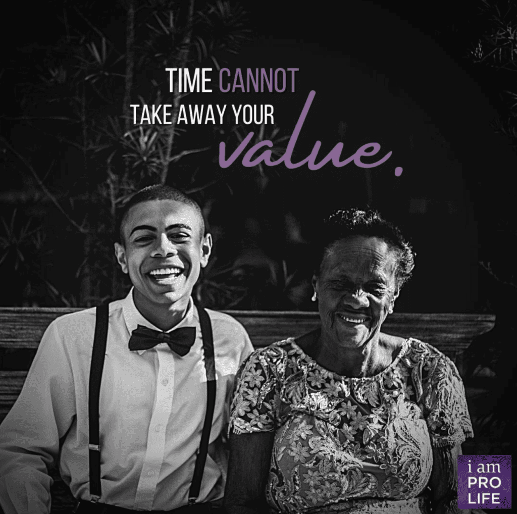 An elderly woman and her grandson sit laughing on a bench together after church.