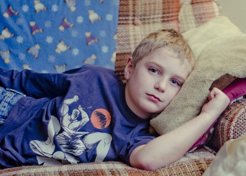 sad little boy lying on couch