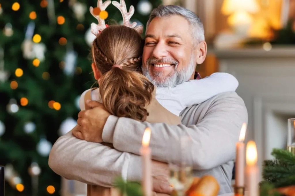 Grandfather hugging his granddaughter at Christmas